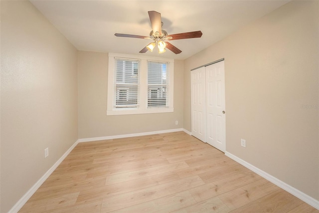 unfurnished bedroom featuring ceiling fan, light hardwood / wood-style floors, and a closet