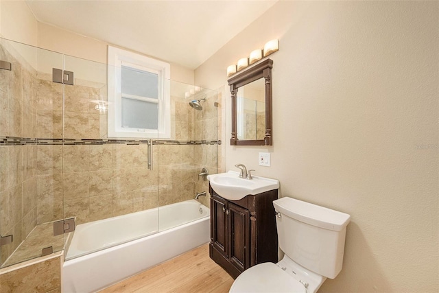 full bathroom featuring hardwood / wood-style floors, vanity, toilet, and enclosed tub / shower combo