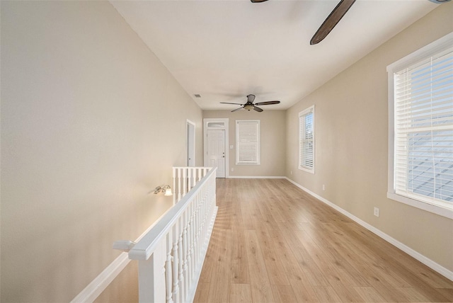 spare room with ceiling fan, plenty of natural light, and light wood-type flooring