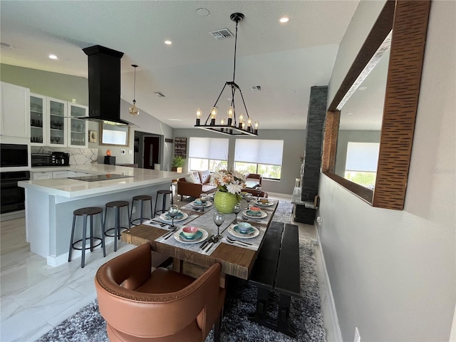 dining room featuring a notable chandelier and vaulted ceiling