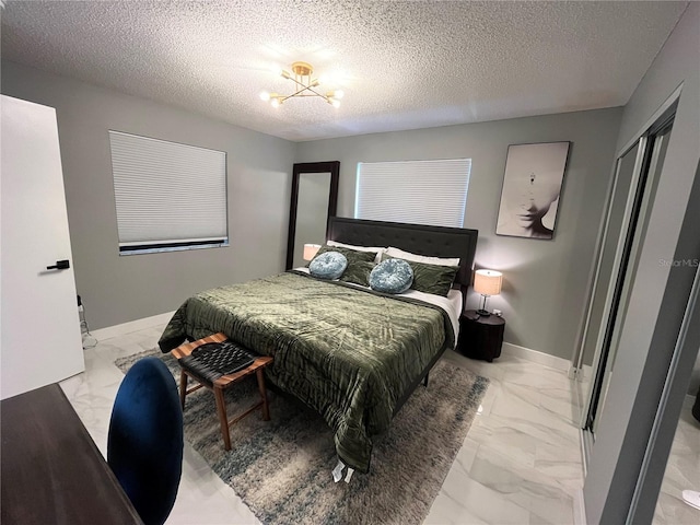 bedroom featuring a notable chandelier and a textured ceiling