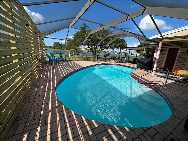 view of pool with glass enclosure and a patio area