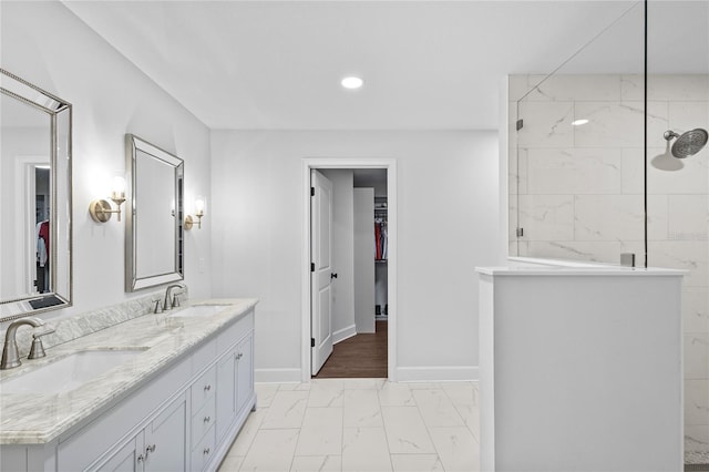 bathroom with tiled shower and vanity