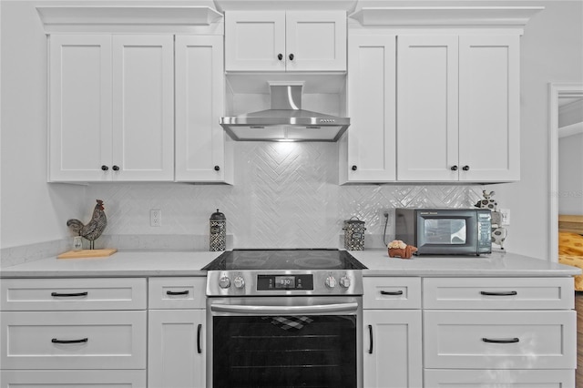 kitchen featuring white cabinetry, backsplash, electric range, and wall chimney exhaust hood