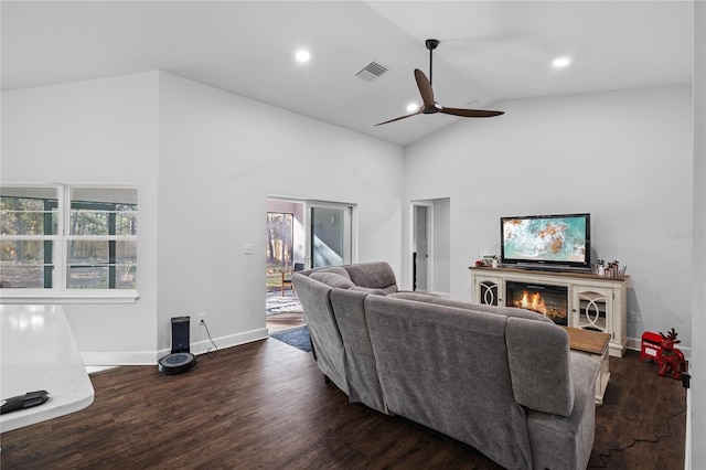 living room with ceiling fan, high vaulted ceiling, and dark wood-type flooring