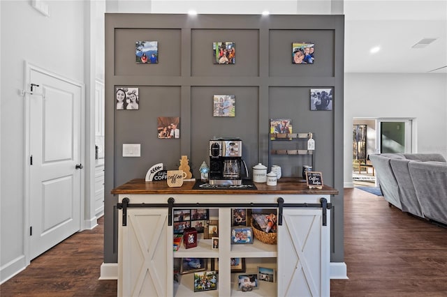 bar with gray cabinets, dark hardwood / wood-style floors, a barn door, and wooden counters