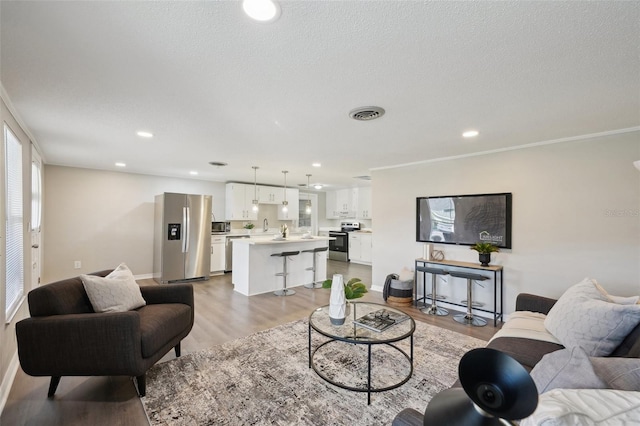 living room with light hardwood / wood-style floors and ornamental molding