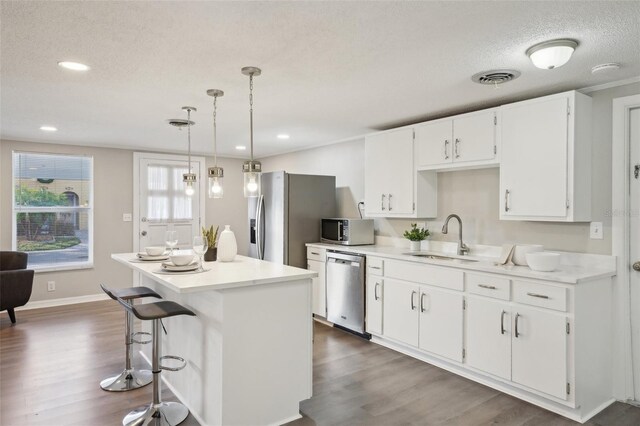 kitchen featuring dishwasher, sink, dark hardwood / wood-style floors, decorative light fixtures, and white cabinets