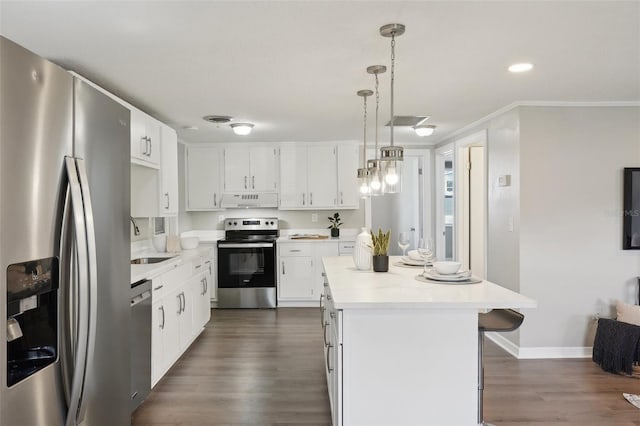 kitchen featuring appliances with stainless steel finishes, extractor fan, white cabinets, a kitchen island, and hanging light fixtures