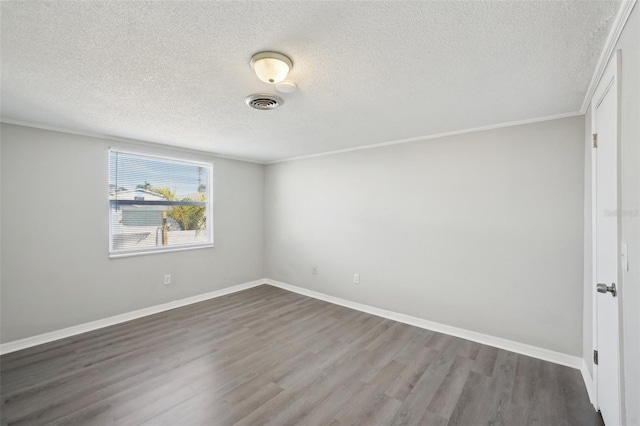 empty room with crown molding, a textured ceiling, and hardwood / wood-style flooring