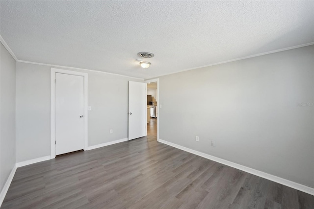 empty room with a textured ceiling and dark hardwood / wood-style flooring