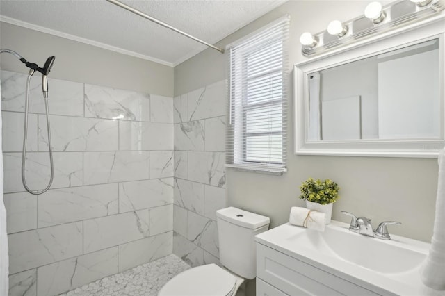 bathroom with tiled shower, vanity, a textured ceiling, and toilet