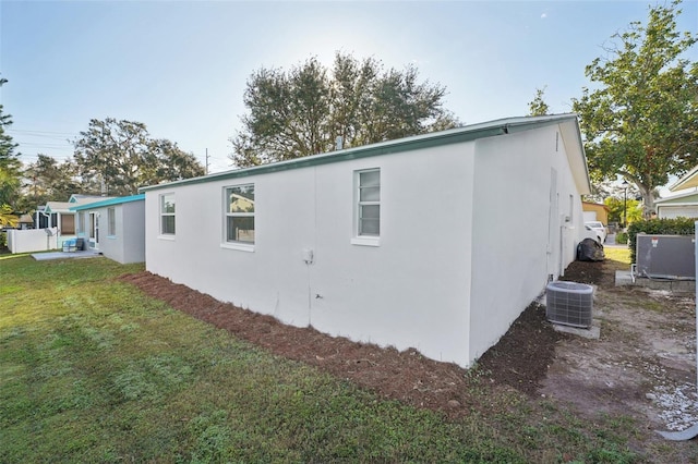 view of side of home with a yard and cooling unit