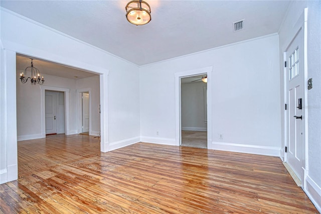 unfurnished room with ceiling fan with notable chandelier, hardwood / wood-style flooring, and ornamental molding