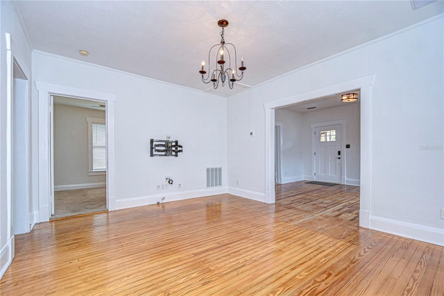 unfurnished room with a notable chandelier, light hardwood / wood-style floors, and ornamental molding