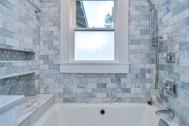 bathroom featuring tiled shower / bath and a wealth of natural light