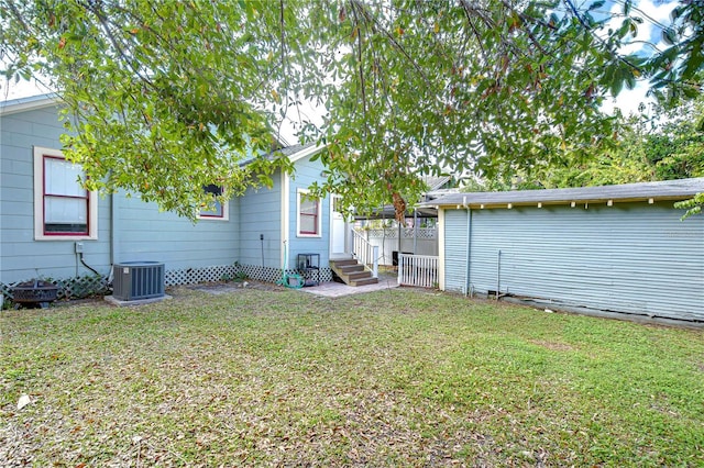 rear view of house featuring a lawn and cooling unit