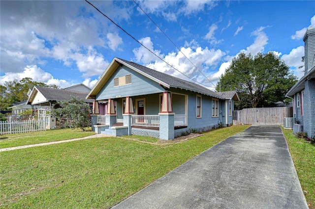 bungalow-style house with cooling unit, covered porch, and a front lawn