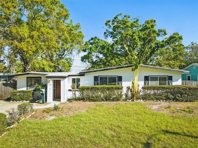 ranch-style house featuring a front yard and fence