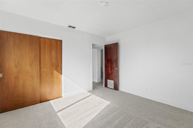 unfurnished bedroom with baseboards, visible vents, a closet, and carpet floors