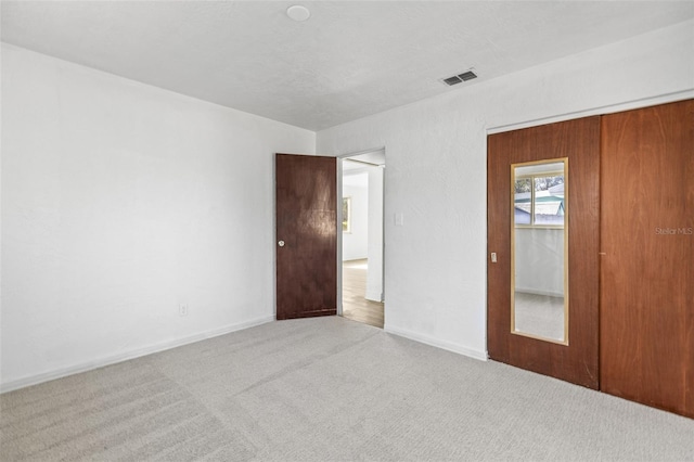 unfurnished bedroom featuring visible vents and carpet flooring