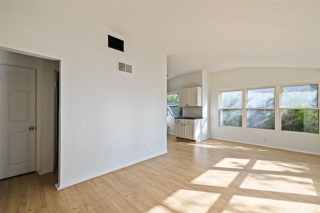 interior space featuring lofted ceiling and light hardwood / wood-style flooring