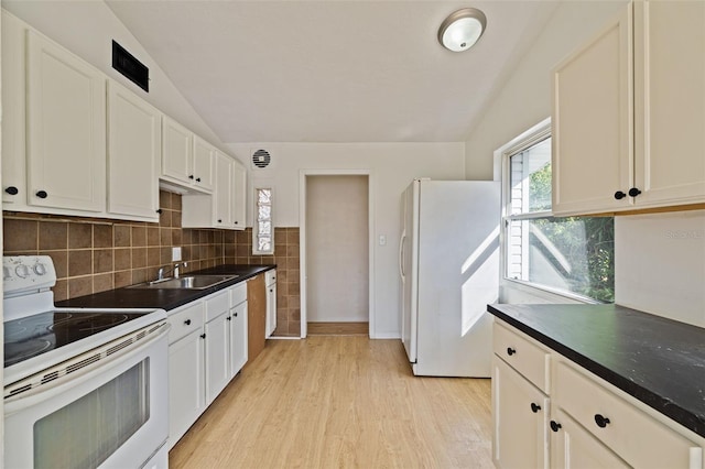 kitchen with lofted ceiling, light hardwood / wood-style floors, white appliances, and sink