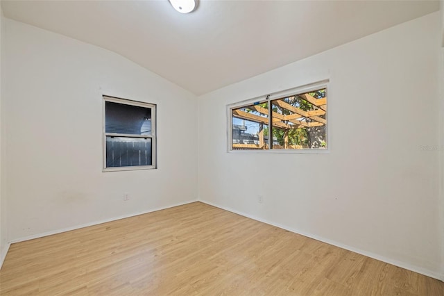 unfurnished room with vaulted ceiling and light hardwood / wood-style flooring