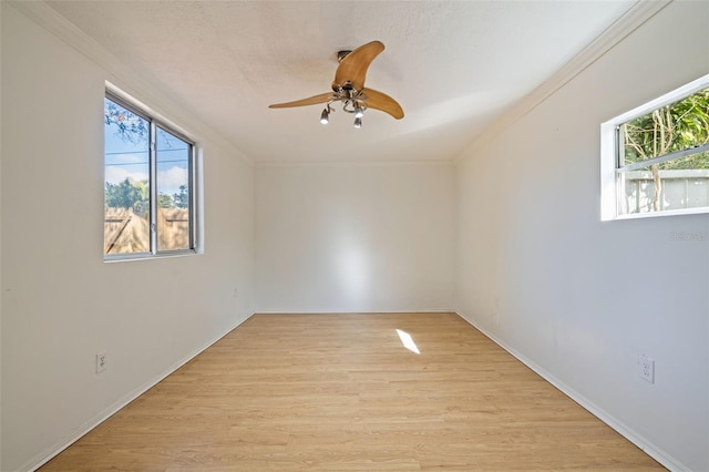 empty room with ceiling fan, crown molding, and light wood-type flooring