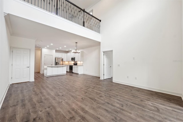 unfurnished living room featuring dark hardwood / wood-style floors and a high ceiling