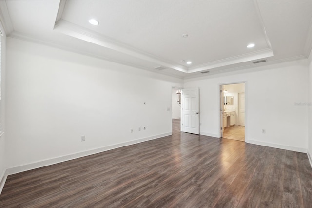 unfurnished bedroom with ensuite bathroom, dark hardwood / wood-style floors, a raised ceiling, and ornamental molding