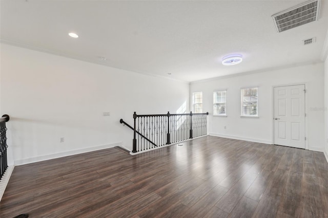 unfurnished living room featuring dark hardwood / wood-style flooring and crown molding