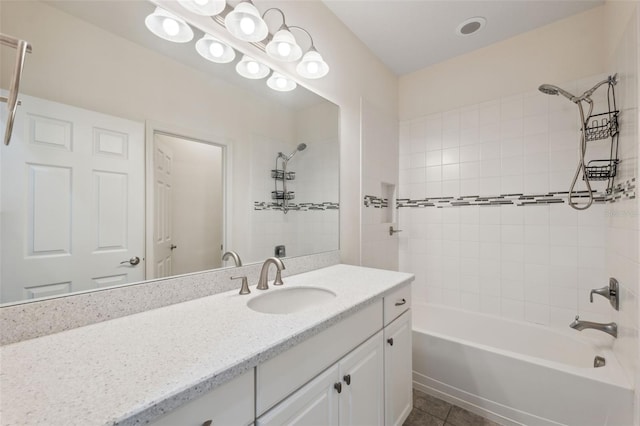 bathroom featuring tile patterned flooring, vanity, and tiled shower / bath