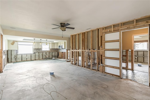 interior space featuring ceiling fan, visible vents, and concrete flooring