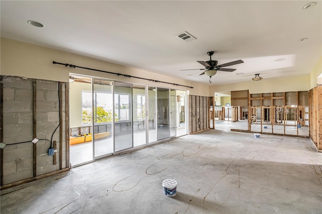 interior space featuring a ceiling fan, visible vents, and unfinished concrete floors