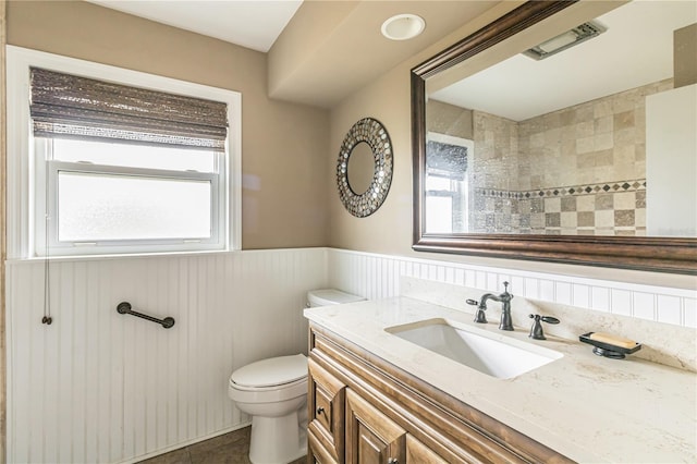 bathroom featuring a wainscoted wall, vanity, and toilet