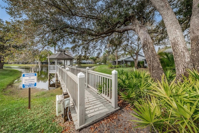 view of home's community with a gazebo, a water view, and a yard