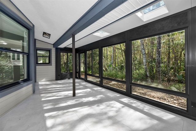 unfurnished sunroom featuring vaulted ceiling with skylight