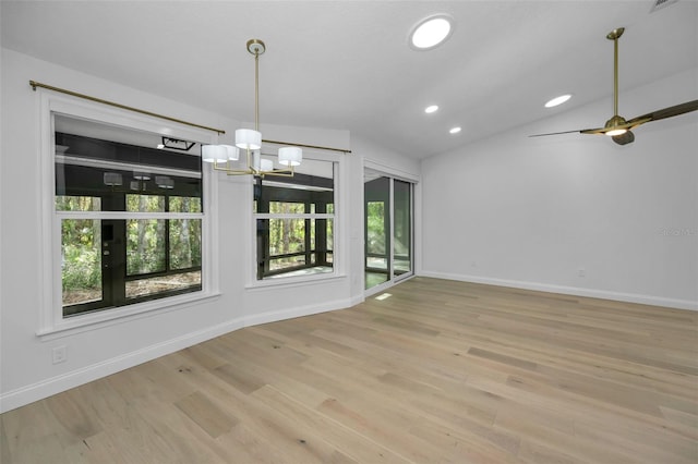 unfurnished dining area featuring ceiling fan with notable chandelier, light hardwood / wood-style floors, and lofted ceiling