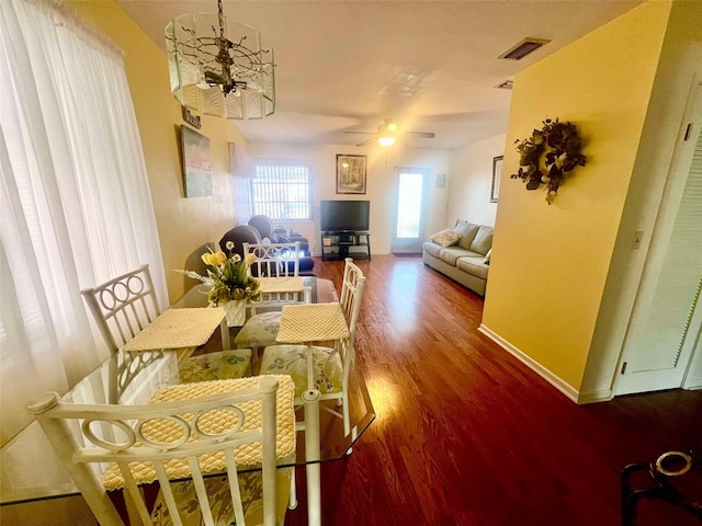 dining space featuring hardwood / wood-style floors and ceiling fan with notable chandelier