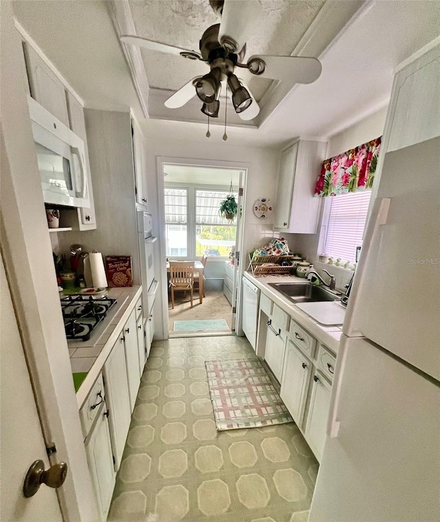 kitchen with sink, white appliances, white cabinetry, and ceiling fan