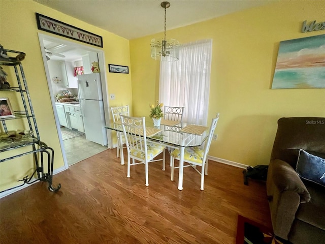 dining room featuring light wood-type flooring and an inviting chandelier