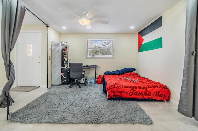 tiled bedroom featuring ceiling fan