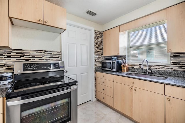 kitchen featuring tasteful backsplash, sink, light brown cabinets, and appliances with stainless steel finishes