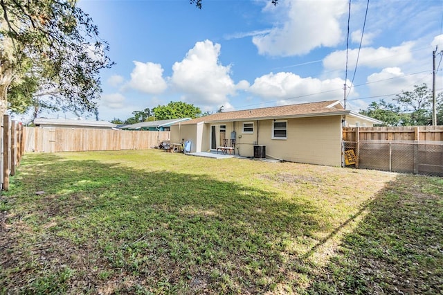 rear view of property with a yard and central AC