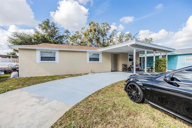 view of front of property with a front lawn and a carport