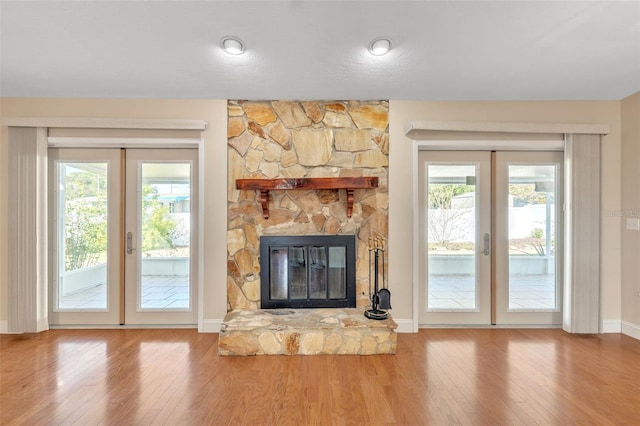 unfurnished living room featuring french doors, hardwood / wood-style flooring, and a wealth of natural light