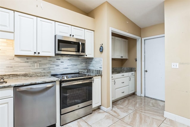 kitchen featuring white cabinets, backsplash, stainless steel appliances, and vaulted ceiling