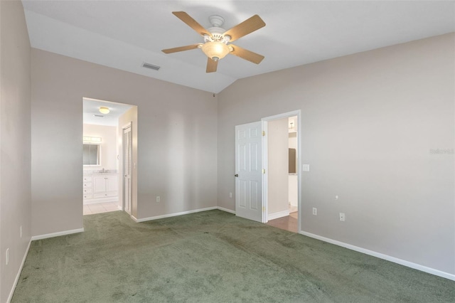 unfurnished bedroom featuring carpet floors, ensuite bathroom, ceiling fan, and lofted ceiling