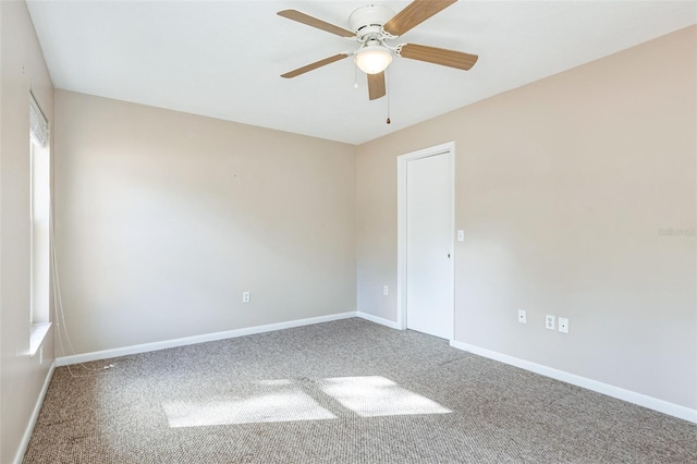 carpeted spare room with ceiling fan